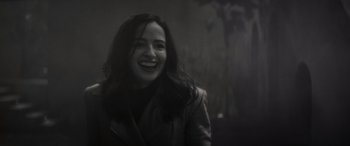Movie still from “Werewolf by Night” (2022), directed by Michael Giacchino – A woman smiling and wearing a leather jacket; Close Up shot, Over the shoulder angle