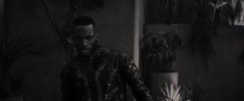 Movie still from “Werewolf by Night” (2022), directed by Michael Giacchino – A black and white photo of a man in a suit; Close Up shot, Over the shoulder angle