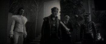 Movie still from “Werewolf by Night” (2022), directed by Michael Giacchino – A man and a woman standing next to each other holding a sword; Medium shot, Over the shoulder angle