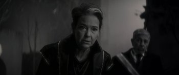 Movie still from “Werewolf by Night” (2022), directed by Michael Giacchino – An older woman is looking at the camera; Close Up shot, Over the shoulder angle