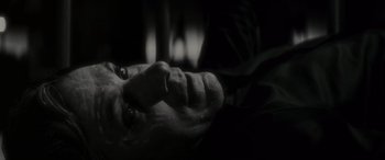 Movie still from “Werewolf by Night” (2022), directed by Michael Giacchino – A black and white photo of a man laying on the ground; Close Up shot, High angle
