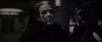 Movie still from “Werewolf by Night” (2022), directed by Michael Giacchino – An older woman with a black eye and a black jacket; Close Up shot, Low angle