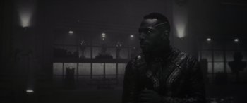 Movie still from “Werewolf by Night” (2022), directed by Michael Giacchino – A black and white photo of a man in a dark room; Close Up shot, Over the shoulder angle