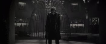 Movie still from “Werewolf by Night” (2022), directed by Michael Giacchino – A woman standing in front of an iron cage; Wide shot, Low angle