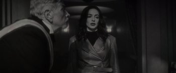 Movie still from “Werewolf by Night” (2022), directed by Michael Giacchino – A man and a woman standing in a elevator; Medium shot, Over the shoulder angle