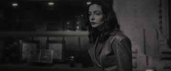 Movie still from “Werewolf by Night” (2022), directed by Michael Giacchino – A black and white photo of a woman in a leather jacket; Medium shot, Low angle