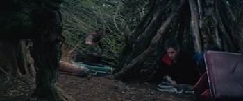 Movie still from “Werewolf by Night” (2022), directed by Michael Giacchino – A man sitting under a tree next to an old record player; Wide shot, High angle