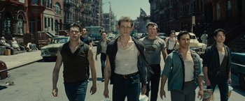 Movie still from “West Side Story” (2021), directed by Steven Spielberg – A group of young men walking down a street; Medium shot, Low angle