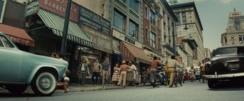 Movie still from “West Side Story” (2021), directed by Steven Spielberg – A group of people walking down a street; Extreme Wide shot, High angle
