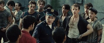 Movie still from “West Side Story” (2021), directed by Steven Spielberg – A group of men standing next to each other in a room; Medium shot, Over the shoulder angle