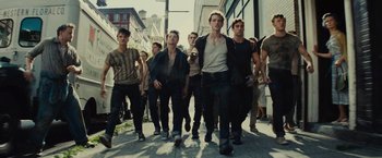 Movie still from “West Side Story” (2021), directed by Steven Spielberg – A group of young men walking down a sidewalk; Wide shot, Low angle