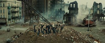 Movie still from “West Side Story” (2021), directed by Steven Spielberg – A group of men standing in the rubble of a city; Wide shot, High angle