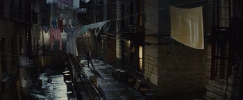 Movie still from “West Side Story” (2021), directed by Steven Spielberg – A street scene with a person walking on the sidewalk; Extreme Wide shot, High angle