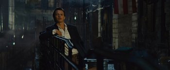 Movie still from “West Side Story” (2021), directed by Steven Spielberg – A man leaning on a railing in the dark; Medium shot, Low angle