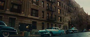 Movie still from “West Side Story” (2021), directed by Steven Spielberg – An old car parked on the side of the street; Extreme Wide shot, Low angle