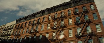 Movie still from “West Side Story” (2021), directed by Steven Spielberg – A building with fire escapes on the side of the building; Extreme Wide shot, Low angle