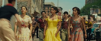 Movie still from “West Side Story” (2021), directed by Steven Spielberg – A group of people walking down a street; Medium shot, Low angle