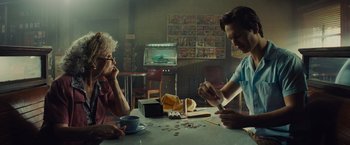 Movie still from “West Side Story” (2021), directed by Steven Spielberg – Two people sitting at a table playing a card game; Medium shot, Over the shoulder angle