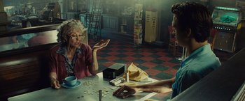 Movie still from “West Side Story” (2021), directed by Steven Spielberg – Two people sitting at a table in a restaurant; Medium shot, Over the shoulder angle