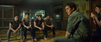 Movie still from “West Side Story” (2021), directed by Steven Spielberg – A group of young men sitting in a living room; Medium shot, Over the shoulder angle