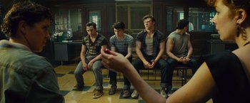 Movie still from “West Side Story” (2021), directed by Steven Spielberg – A group of young men sitting in front of an instructor; Medium shot, Over the shoulder angle