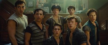 Movie still from “West Side Story” (2021), directed by Steven Spielberg – A group of young men standing next to each other in a courtroom; Medium shot, High angle