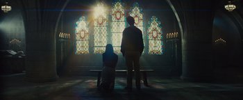 Movie still from “West Side Story” (2021), directed by Steven Spielberg – A man and a woman standing in front of a stained glass window; Wide shot, Low angle