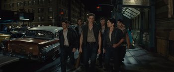 Movie still from “West Side Story” (2021), directed by Steven Spielberg – A group of young men walking down a street; Medium shot, High angle