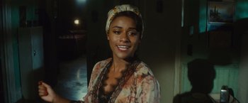 Movie still from “West Side Story” (2021), directed by Steven Spielberg – A woman wearing a head scarf smiling for the camera; Close Up shot, Over the shoulder angle