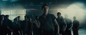 Movie still from “West Side Story” (2021), directed by Steven Spielberg – A group of men standing in a dark room; Medium shot, Low angle