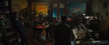 Movie still from “West Side Story” (2021), directed by Steven Spielberg – A group of people sitting at a table in a restaurant; Wide shot, High angle