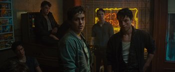 Movie still from “West Side Story” (2021), directed by Steven Spielberg – A group of young men standing next to each other in a room; Medium shot, Over the shoulder angle