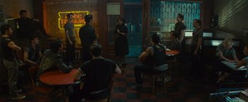 Movie still from “West Side Story” (2021), directed by Steven Spielberg – A group of people sitting in a room; Wide shot, Over the shoulder angle