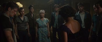 Movie still from “West Side Story” (2021), directed by Steven Spielberg – A group of people standing next to each other in a room; Medium shot, Over the shoulder angle