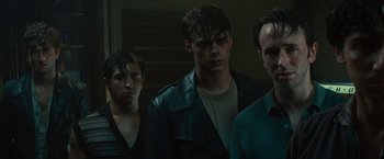Movie still from “West Side Story” (2021), directed by Steven Spielberg – A group of young men standing next to each other; Medium shot, Low angle
