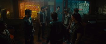 Movie still from “West Side Story” (2021), directed by Steven Spielberg – A group of young men standing around in a room; Wide shot, Over the shoulder angle