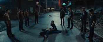Movie still from “West Side Story” (2021), directed by Steven Spielberg – A group of people standing on the side of a road; Wide shot, High angle
