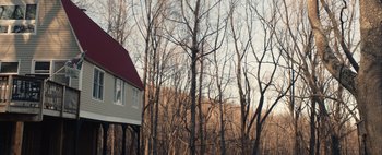 Movie still from “What She Said” (2021), directed by Amy Northup – A house sitting in the middle of a forest; Extreme Wide shot, Low angle