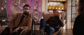 Movie still from “What's Love Got to Do with It?” (2022), directed by Shekhar Kapur – A couple of men sitting on top of a chair; Medium shot, Low angle