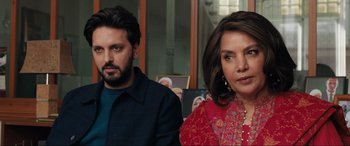 Movie still from “What's Love Got to Do with It?” (2022), directed by Shekhar Kapur – A man and a woman sitting next to each other in a room; Close Up shot, Over the shoulder angle