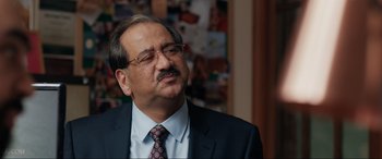 Movie still from “What's Love Got to Do with It?” (2022), directed by Shekhar Kapur – A person wearing a suit and tie; Close Up shot, Over the shoulder angle