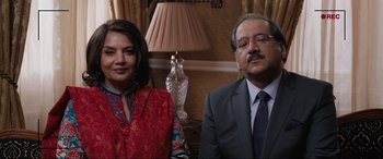 Movie still from “What's Love Got to Do with It?” (2022), directed by Shekhar Kapur – A man and a woman sitting next to each other in front of a lamp; Medium shot, High angle
