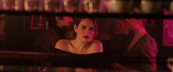 A woman sitting in front of a man in a red light