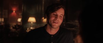 Movie still from “What's Love Got to Do with It?” (2022), directed by Shekhar Kapur – A person wearing a black shirt smiling; Close Up shot, Over the shoulder angle