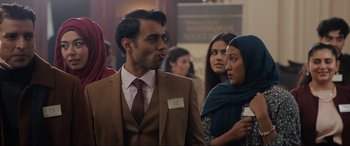 Movie still from “What's Love Got to Do with It?” (2022), directed by Shekhar Kapur – A group of people standing in a room; Medium shot, Over the shoulder angle