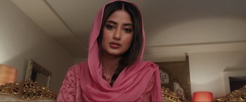 Movie still from “What's Love Got to Do with It?” (2022), directed by Shekhar Kapur – A woman in a pink dress with a pink scarf around her head; Close Up shot, Over the shoulder angle