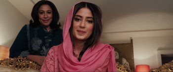 Movie still from “What's Love Got to Do with It?” (2022), directed by Shekhar Kapur – A woman in a pink dress with a pink scarf around her head; Close Up shot, Over the shoulder angle