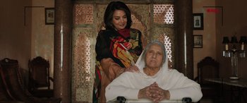 Movie still from “What's Love Got to Do with It?” (2022), directed by Shekhar Kapur – An older woman sitting in front of an older woman; Medium shot, High angle