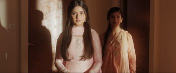 Movie still from “What's Love Got to Do with It?” (2022), directed by Shekhar Kapur – Two young women standing next to each other in a room; Medium shot, Low angle
