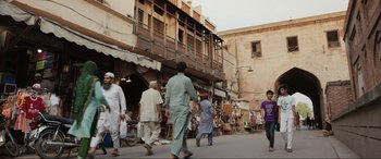 Movie still from “What's Love Got to Do with It?” (2022), directed by Shekhar Kapur – A group of people walking down a street; Extreme Wide shot, Over the shoulder angle